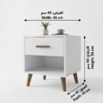 كمودينو بيانكو أبيض مودرن من آدم فرنتشر، يحتوي على درج بمقبض خشبي ورف مفتوح، ويرتكز على أرجل خشبية دافئة تتناسق مع التصميم.